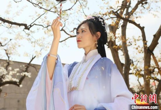 圖為蘭州青年身穿漢服在百年梨園賞景?！「哒?攝