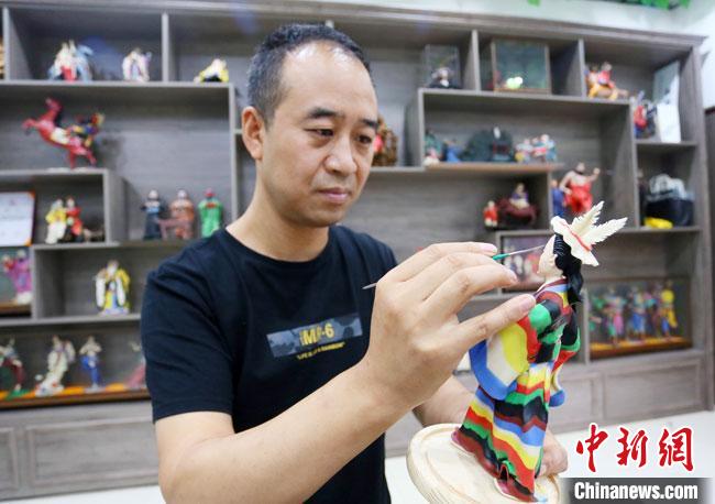 圖為安秋平正在創(chuàng)作代表隴南文縣民俗的《白馬人》作品?！「哒?攝