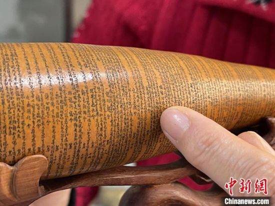 圖為長約二十公分的長條葫蘆雕刻佛教經(jīng)文作品。　張婧 攝