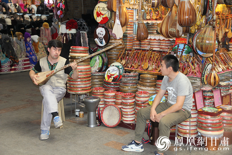 烏魯木齊二道橋巴扎內(nèi)，店主正在向客人展示樂器。楊文遠(yuǎn) 攝