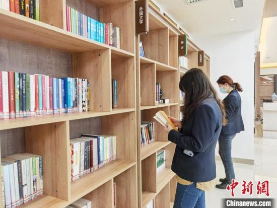 圖為在甘肅公航旅建設(shè)集團(tuán)有限公司的職工書屋，職工挑選書籍?！⌒煅?攝