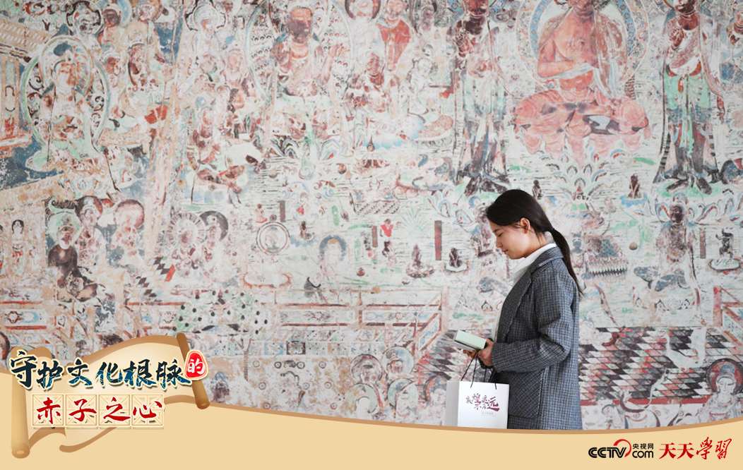 2023年4月25日，敦煌研究院文物數(shù)字化保護(hù)團(tuán)隊(duì)創(chuàng)意營銷人員廖雪婷從一幅高保真復(fù)制壁畫前走過。