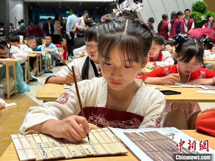 圖為小朋友在甘肅簡(jiǎn)牘博物館練習(xí)書法?！≈行律缬浾?戴文昌 攝