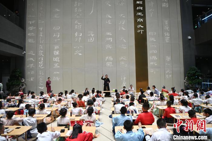 圖為9月7日，甘肅簡牘博物館開館儀式在蘭州舉行，小朋友們學(xué)習(xí)書寫簡牘中的文字?！≈行律缬浾?九美旦增 攝
