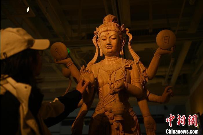 圖為季茂杰觀察自己創(chuàng)作的敦煌木雕。李亞龍 攝</p>
<p>