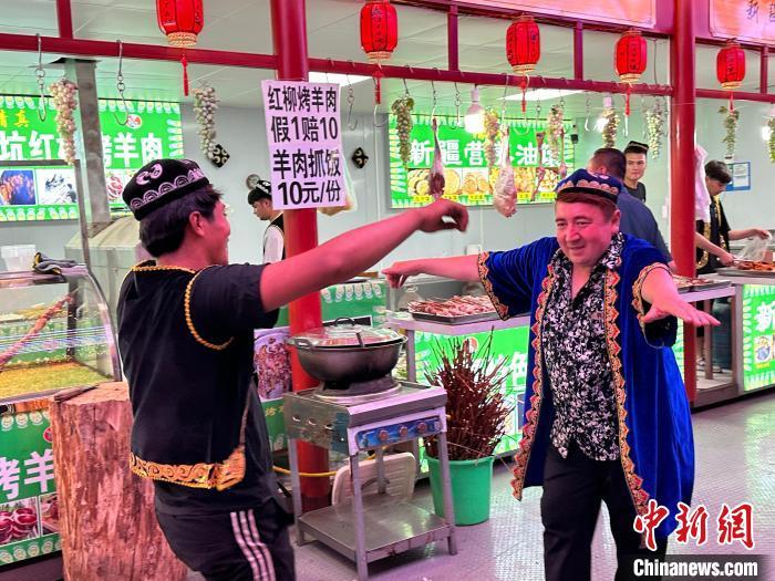 圖為餐飲經(jīng)營者在“西涼不夜城”跳起舞蹈引客?！〈魑牟?攝</p><p>